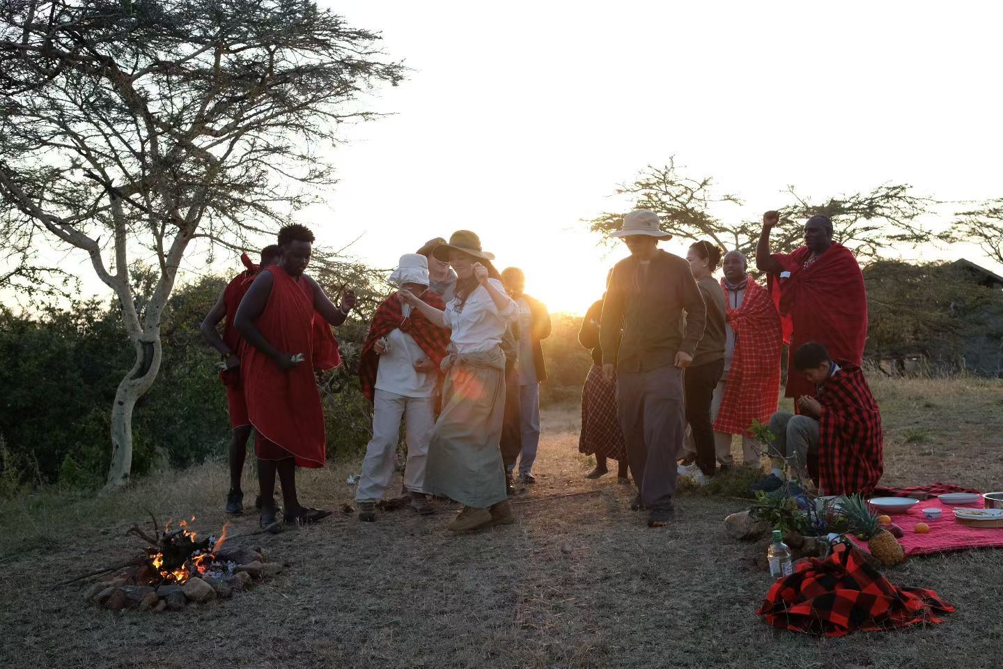 Guests and Maasai hosts gathered at sunset near Sausage Tree